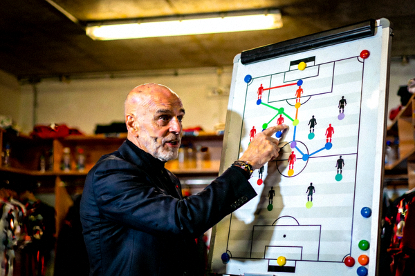 AC米兰主教练皮奥利在战术板前讲解战术的严肃场景